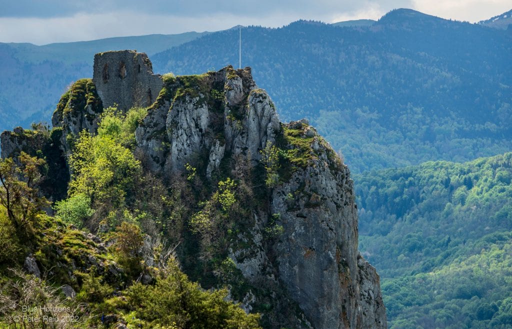 A dilapidated castle build on an mountain peak