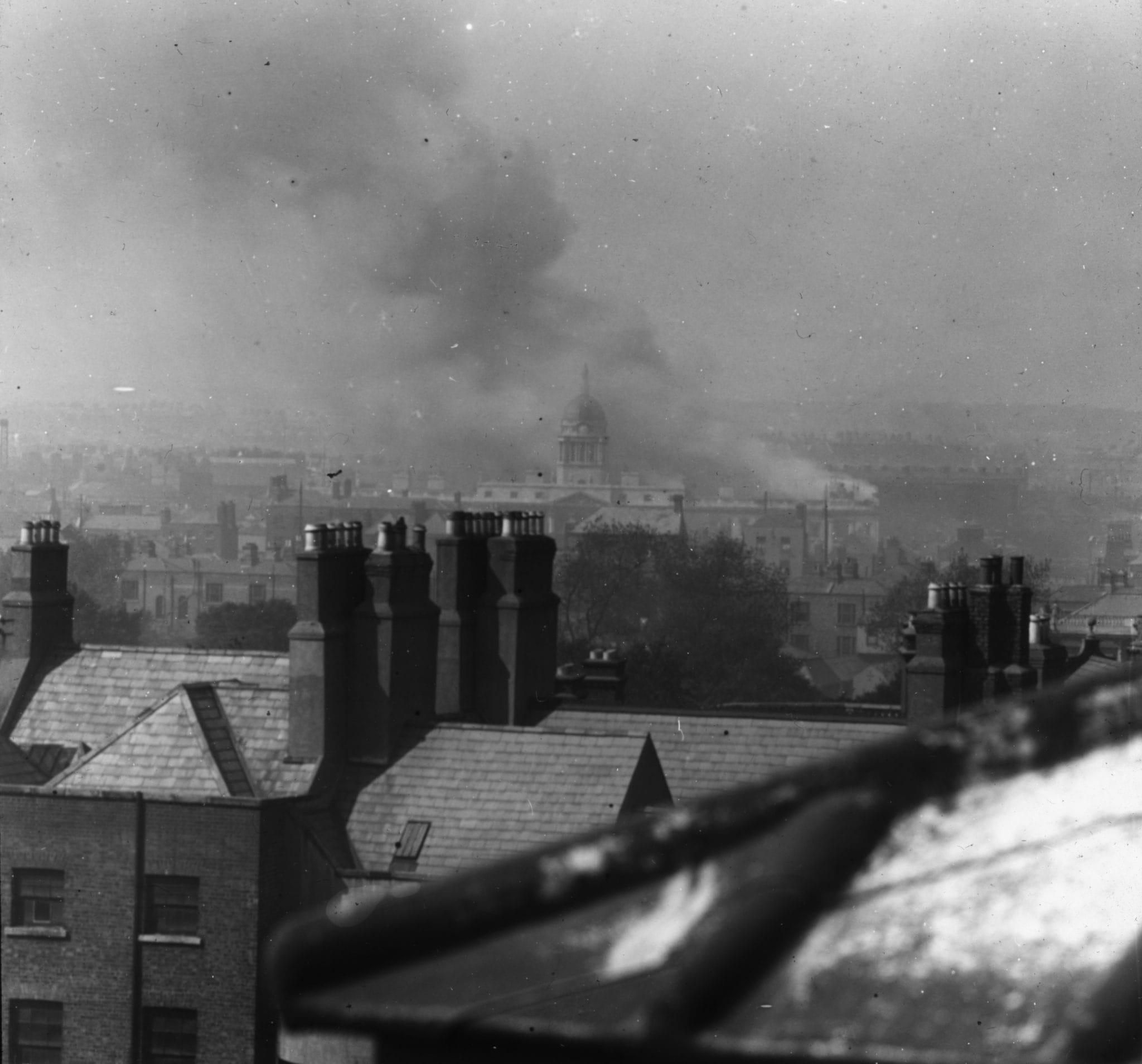 Black and whie photograph of the Custom House, Dublin, on fire taken from the roof of the National Gallery on 25 May 1921. The image is form the T.J. Byrne Collection in the IAA.