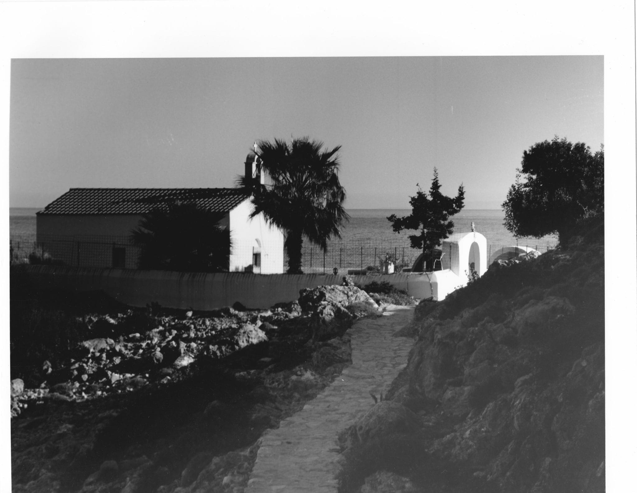 Black and white photograph by Sean McCrum of a Sacred Church on a headland near Loutro, Southern Crete from the collection of the photographer.