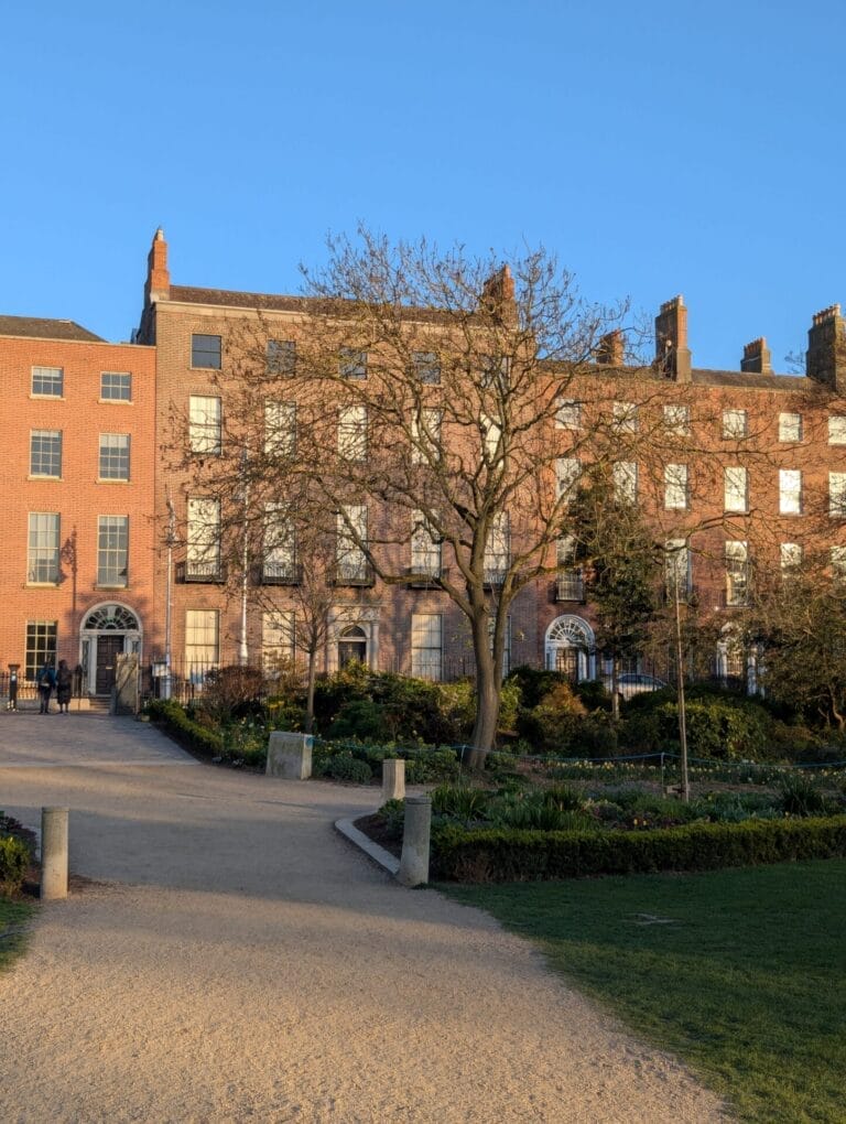 View of 45 Merrion Square from inside Merrion Square Park on a sunny afternoon in April 2025, with a clear blue sky behind the building.