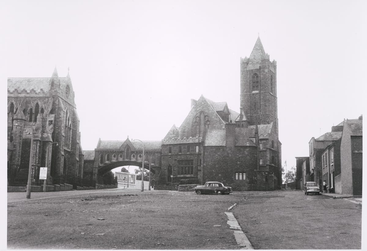 Photograph of Christ Church Cathedral and Synod House, Dublin, taken by Paddy Healy in 1965. Christ Church Cathedral and the Synod House stand in shocking isolation caused by the demolition of most of Winetavern Street for road widening.